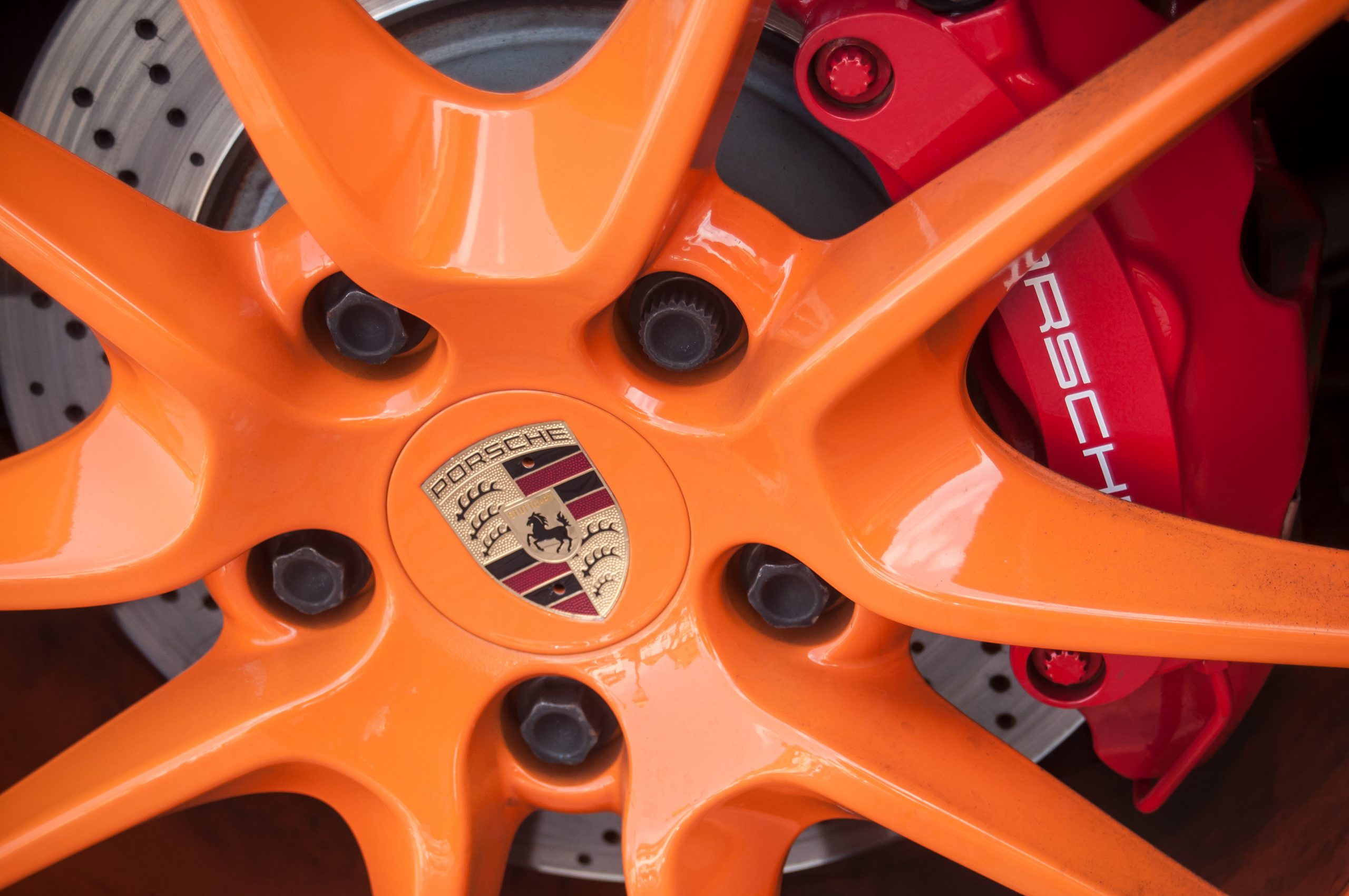 closeup of red break on orange wheel of Porsche 911 sport car